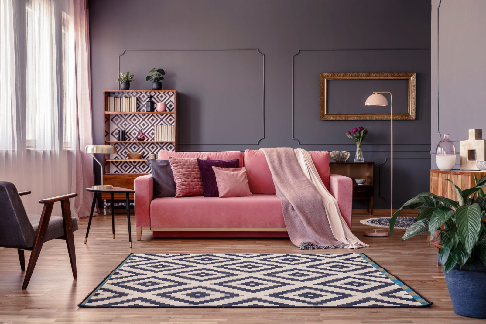 różowa kanapa, dywan, lampa stojąca